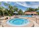 A tranquil hot tub complements the pool area, providing a serene space for relaxation with shaded seating and lush landscaping at 1166 Carmel Cir # 120, Casselberry, FL 32707