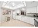 Well-lit kitchen featuring white cabinets, appliances, tile floor, and a view to the adjacent dining room at 1166 Carmel Cir # 120, Casselberry, FL 32707