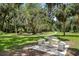 Park-like setting with mature trees and benches provides a peaceful escape with a beautiful stone table and seating at 1166 Carmel Cir # 120, Casselberry, FL 32707