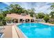 Community pool with lounge chairs, umbrellas, and a building for restrooms and shade at 1166 Carmel Cir # 120, Casselberry, FL 32707