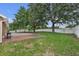 Expansive backyard with a brick patio, mature trees, and privacy fence, perfect for outdoor entertaining and relaxation at 12713 Pine Arbor Dr, Clermont, FL 34711