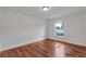 A well lit bedroom featuring hardwood floors, white walls and a window at 12713 Pine Arbor Dr, Clermont, FL 34711