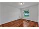 A bright bedroom featuring hardwood floors, white walls and a window at 12713 Pine Arbor Dr, Clermont, FL 34711