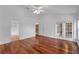 A bright bedroom featuring wood floors, a ceiling fan and access to an outdoor patio at 12713 Pine Arbor Dr, Clermont, FL 34711