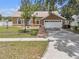 Charming one-story home featuring a two-car garage, manicured lawn, and welcoming curb appeal at 12713 Pine Arbor Dr, Clermont, FL 34711