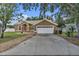 Charming home with a well-manicured lawn, two-car garage, arched entry, and beautiful landscaping at 12713 Pine Arbor Dr, Clermont, FL 34711
