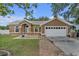 Beautiful single-story home with a well-maintained lawn, a two-car garage and elegant architectural details at 12713 Pine Arbor Dr, Clermont, FL 34711