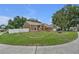Landscaped front yard features green grass, mature trees, white fence and a well-maintained lawn at 12713 Pine Arbor Dr, Clermont, FL 34711