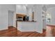 Bright open-concept area featuring hardwood floors, kitchen counter, and arched doorways at 12713 Pine Arbor Dr, Clermont, FL 34711
