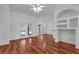 Bright living room featuring hardwood floors, French doors, and an arched window for natural light at 12713 Pine Arbor Dr, Clermont, FL 34711