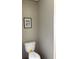 Clean, white toilet with neutral wall color and framed floral print create a simple powder room at 1349 Nw 109 Ave, Ocala, FL 34482