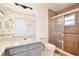 Bathroom showcasing a single sink vanity and a tiled shower enclosure with glass sliding doors at 14063 Ithaca Way, Orlando, FL 32826