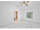 Bright bedroom with white walls, white tile flooring, ceiling fan, and an attached bathroom at 14063 Ithaca Way, Orlando, FL 32826