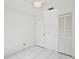 A simple, clean bedroom with a white tile floor and a ceiling fan at 14063 Ithaca Way, Orlando, FL 32826