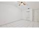 Spacious bedroom featuring white walls, white tile flooring, ceiling fan and a mirrored closet at 14063 Ithaca Way, Orlando, FL 32826