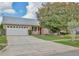 Well-maintained single-story home boasts a two-car garage, manicured lawn, and a freshly painted exterior at 14063 Ithaca Way, Orlando, FL 32826