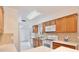 Modern kitchen featuring wood cabinets, white appliances, and easy access to a backyard area and natural light at 14063 Ithaca Way, Orlando, FL 32826