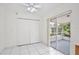 Well-lit room featuring white tile floors, a ceiling fan, and sliding doors to a screened-in patio at 14063 Ithaca Way, Orlando, FL 32826