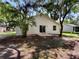 Home's backyard featuring large trees and home exterior at 142 E 9Th St, Chuluota, FL 32766