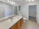 Bathroom with white countertops, wood cabinets, sink, toilet, walk-in closet, and shower in the background at 142 E 9Th St, Chuluota, FL 32766