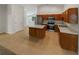 Bright kitchen with stainless steel appliances, island, and views into the dining room at 142 E 9Th St, Chuluota, FL 32766