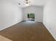 Spacious living room showcasing vaulted ceilings, plush carpeting, and sliding glass door at 142 E 9Th St, Chuluota, FL 32766