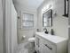 Well-lit bathroom with sleek vanity, a large mirror, and a shower with a curtain at 1642 Mount Vernon St, Orlando, FL 32803