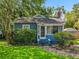 Charming single-story home features a brick chimney, blue siding, and a cozy front porch, surrounded by lush landscaping at 1642 Mount Vernon St, Orlando, FL 32803