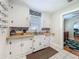 A well-lit kitchen showcases white cabinetry, stainless steel sink, and tiled flooring, blending functionality with classic charm at 1642 Mount Vernon St, Orlando, FL 32803