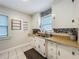 Functional kitchen featuring white cabinets, stainless steel sink, patterned backsplash, and tiled floor for a clean, classic look at 1642 Mount Vernon St, Orlando, FL 32803