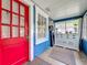 Inviting enclosed porch with bright red door, large windows, and a classic white cabinet, creating a cozy entryway at 1642 Mount Vernon St, Orlando, FL 32803