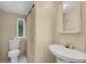 Modest bathroom featuring a toilet, sink, shower curtain, and window at 18166 Lynbrook Rd, Orlando, FL 32820