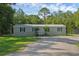 Charming single-story home featuring a well-manicured lawn, a front porch, and mature trees at 18166 Lynbrook Rd, Orlando, FL 32820