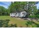 Exterior view of a mobile home on a grassy lot with mature trees at 18166 Lynbrook Rd, Orlando, FL 32820