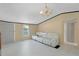 Bright living room featuring white vinyl flooring, a white sofa, and a modern chandelier at 18166 Lynbrook Rd, Orlando, FL 32820