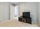 Clean bedroom with carpet, a simple entertainment center and two doors at 21795 Sw 88Th Lane Rd, Dunnellon, FL 34431