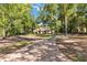 Scenic driveway leading to a charming one-story home surrounded by mature trees and lush landscaping at 21795 Sw 88Th Lane Rd, Dunnellon, FL 34431