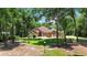 Inviting home featuring a well-manicured lawn, mature trees, and a quaint circular driveway at 21795 Sw 88Th Lane Rd, Dunnellon, FL 34431