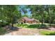 Inviting home featuring a well-manicured lawn, mature trees, and a quaint circular driveway at 21795 Sw 88Th Lane Rd, Dunnellon, FL 34431
