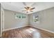 Bright bedroom with wood-look flooring, three windows, and a ceiling fan at 220 Colony Pl, Casselberry, FL 32707