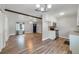 Open-concept living space with wood floors connecting living room and updated kitchen at 220 Colony Pl, Casselberry, FL 32707