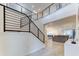 Bright foyer with an open staircase, modern railings, and views to the living room and open-concept kitchen at 2537 Shanti Dr, Kissimmee, FL 34746