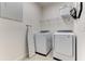Clean laundry room with modern washer and dryer units, an ironing board and storage shelving at 2537 Shanti Dr, Kissimmee, FL 34746