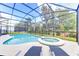 A covered outdoor pool with a jacuzzi and lounge chairs at 2537 Shanti Dr, Kissimmee, FL 34746