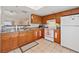Well-lit kitchen with wood cabinets, granite counters, and white appliances at 2753 Beckwith St, Deltona, FL 32738