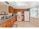 Bright kitchen featuring wood cabinetry and white appliances at 2753 Beckwith St, Deltona, FL 32738