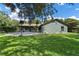Spacious grassy backyard showcasing mature trees, a patio, and a basketball hoop at 3220 Cardigan Ct, Orlando, FL 32812