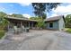 This beautiful backyard features a stone patio, seating, and mature trees at 3220 Cardigan Ct, Orlando, FL 32812