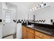 Clean bathroom features a sink, vanity, and large mirror with checkerboard accent tiles at 3220 Cardigan Ct, Orlando, FL 32812