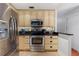 This kitchen has stainless steel appliances and wood cabinetry with black hardware at 3220 Cardigan Ct, Orlando, FL 32812